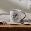 White mug with Bambi design and 'Mum' text on a wooden surface with a tea bag and spoon.