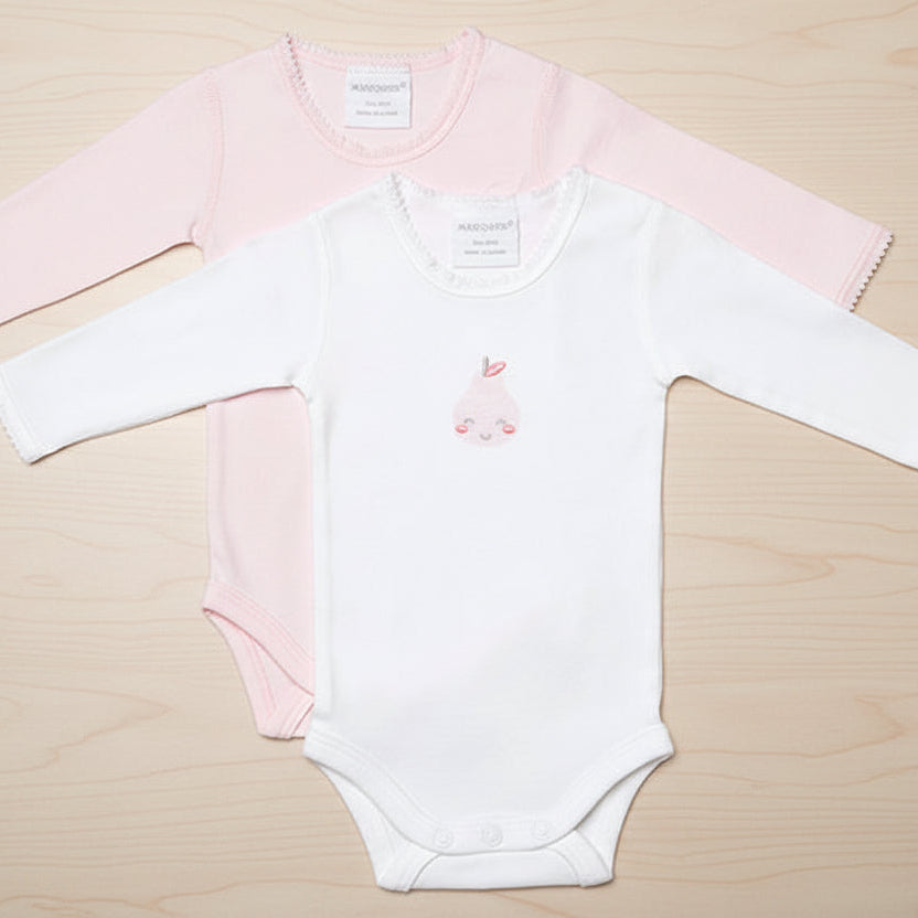 Two baby bodysuits, one pink and one white, on a table background