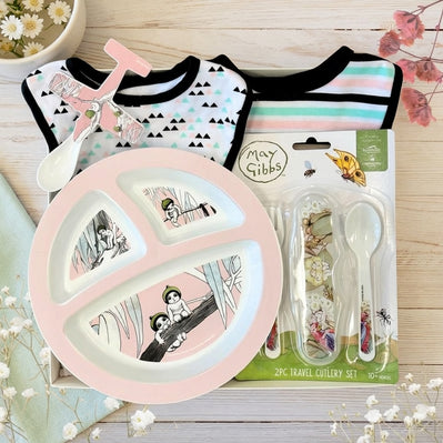 May Gibbs themed gift set with plate, cutlery, and bibs on a wooden surface.