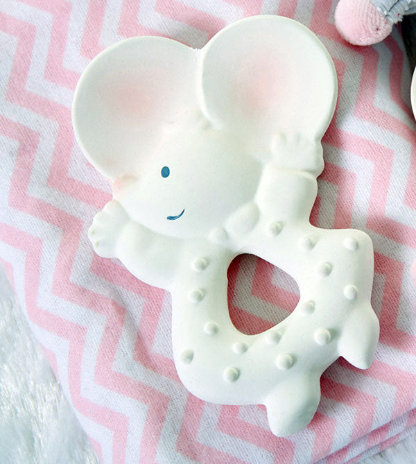 White mouse-shaped teething ring on a pink and white chevron-patterned blanket