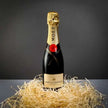 Moet & Chandon Champagne 375ml with hay and dark background
