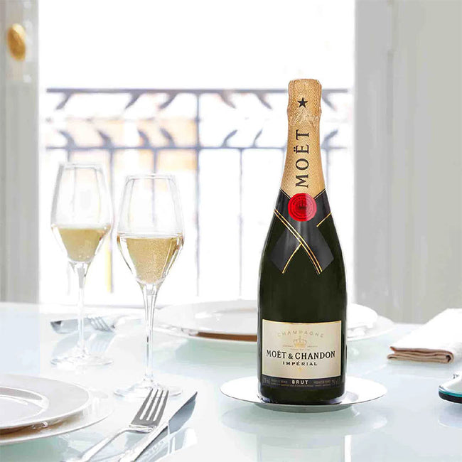 Moét & Chandon champagne bottle on a table with glasses in a dining setting
