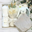 grey bunny, flowers and white blanket within a gift hamper