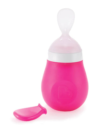Pink and white baby feeding spoon with a cap on a white background