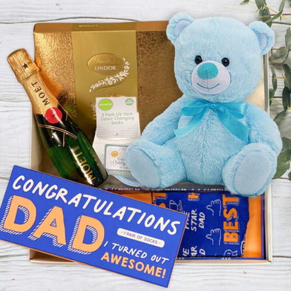 Gift set with blue teddy bear, Moet champagne, Lindor chocolate, and 'Congratulations Dad' socks from The Baby Gift Company