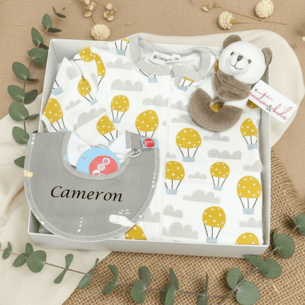 baby gift box with grey bib, teddy bear and baby clothes