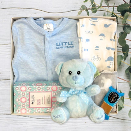 Cute baby boy gift set with blue bear and baby clothing in a gift box