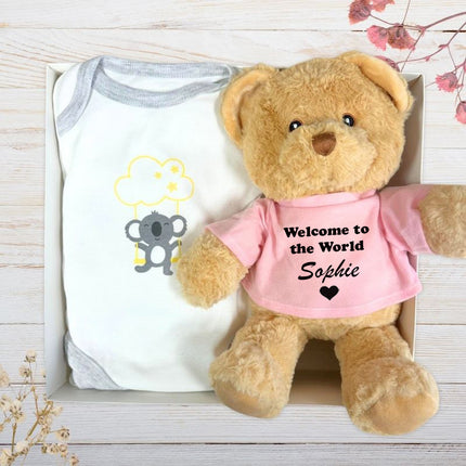 Baby onesie and teddy bear with 'Sophie' text on the Pink top, inside a gift box.