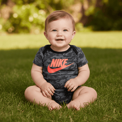 baby sitting outside on grass in nike outfit