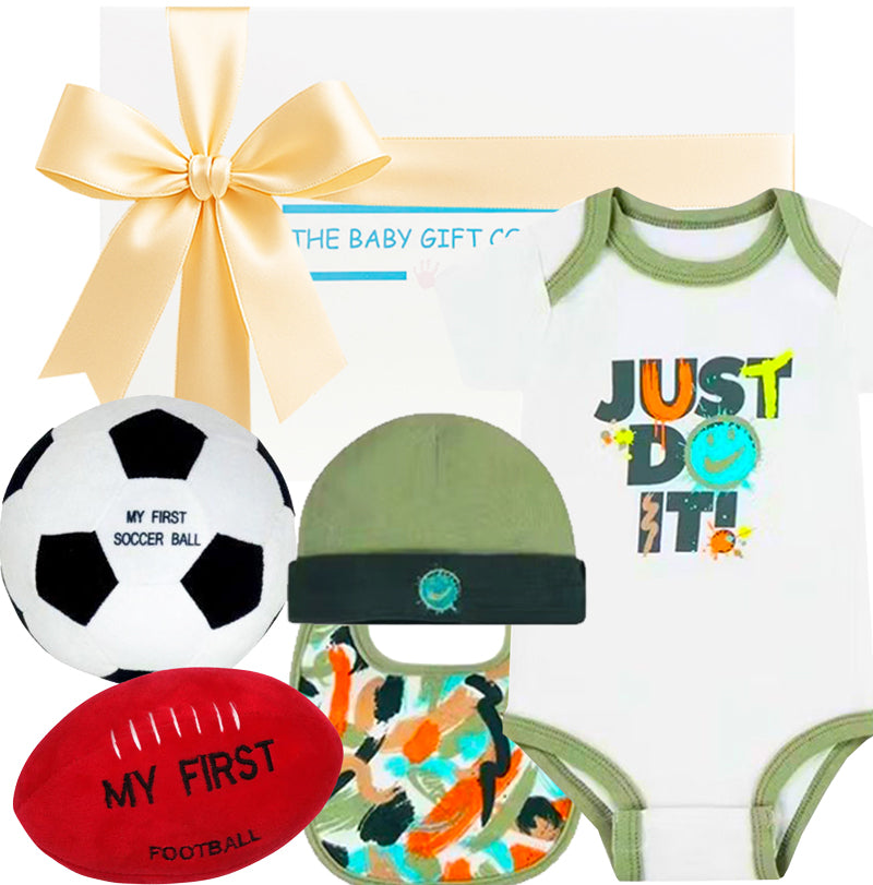 Baby gift set with Nike onesie, soccer ball, football, and bib on a white background.