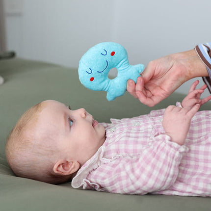 Baby with hand holding blue Octopus Rattle Baby Toy