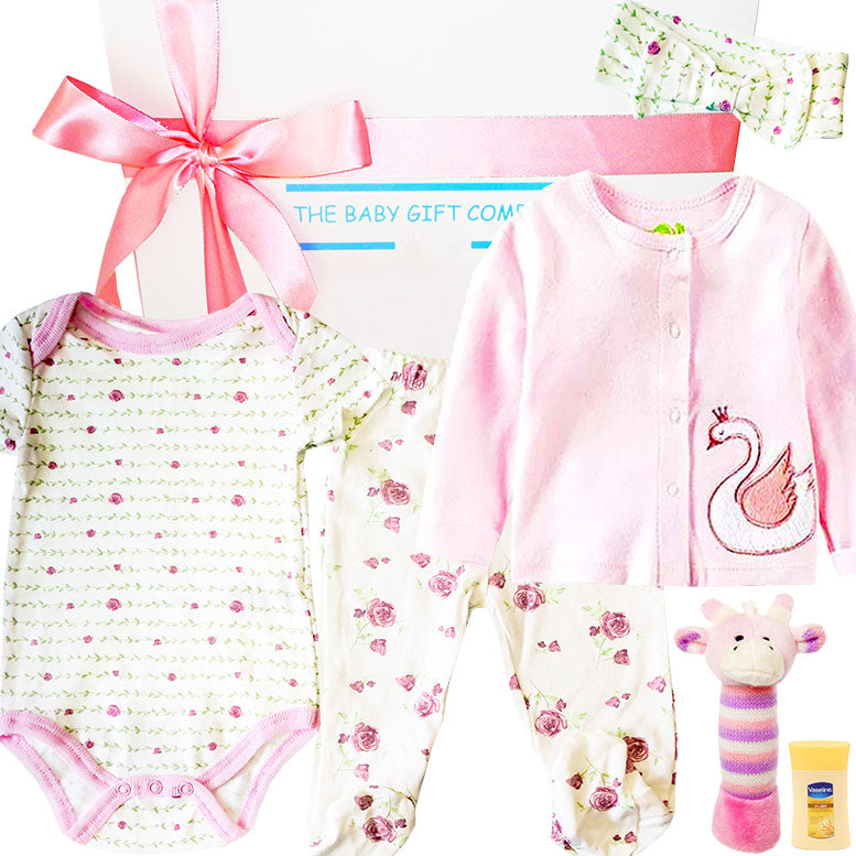 Baby gift set with pink and white baby clothes, a toy, and a bottle on a white background.