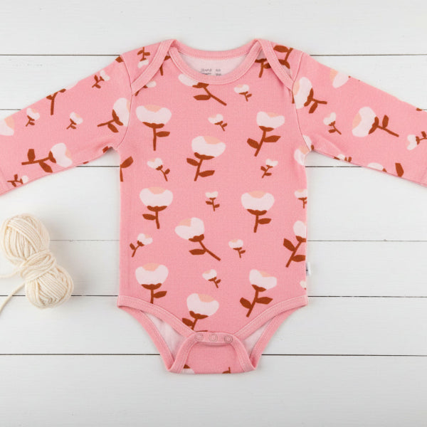 Pink baby onesie with floral pattern on a white background
