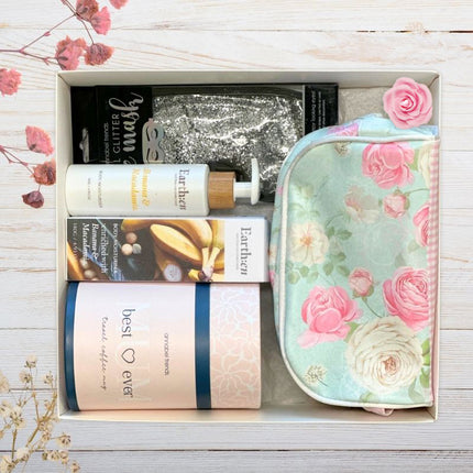 Gift set with skincare products and a floral pouch on a wooden surface.