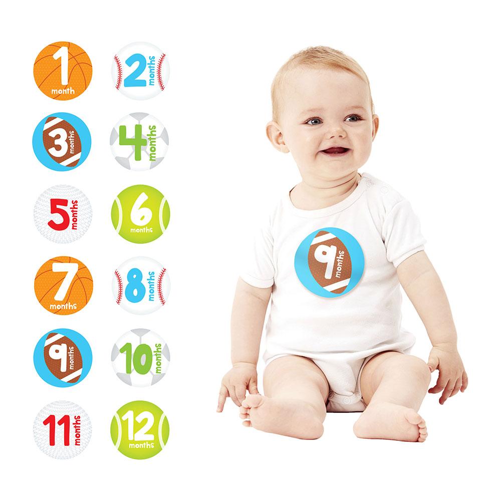 Baby sitting next to milestone stickers indicating months of age.