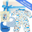 Baby gift set with pajamas, bib, and photo frame on a white background