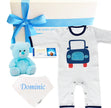 Baby gift set with striped romper, teddy bear, and baby blanket on a white background