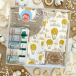 organic baby gift box with grey bib, air balloon clothing and Gaia baby skincare