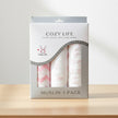 Pink and white 3 pack muslin wraps on Cozy life box on a table