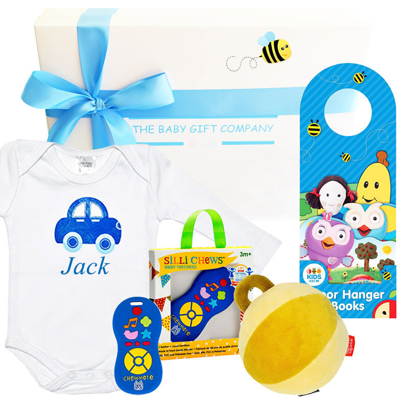 Baby gift set with onesie, toys, and door hanger from The Baby Gift Company.