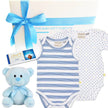 Baby gift set with striped onesie, teddy bear, and Lindt chocolate bar on a white background