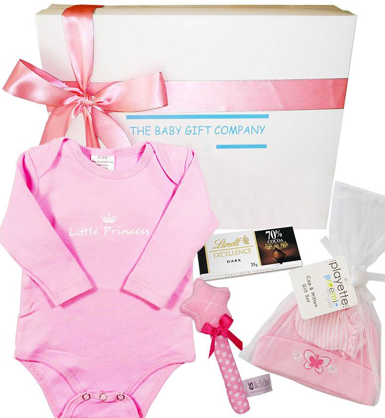 Baby gift set with pink 'Little Princess' outfit, hat, and other items in front of 'The Baby Gift Company' box.