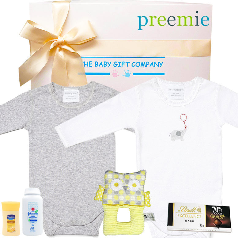Baby gift set with clothes, toys, and snacks on a white background