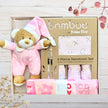 Bamboo by Bubble Blue 3-piece newborn set with teddy bear in pink outfit on a wooden surface.