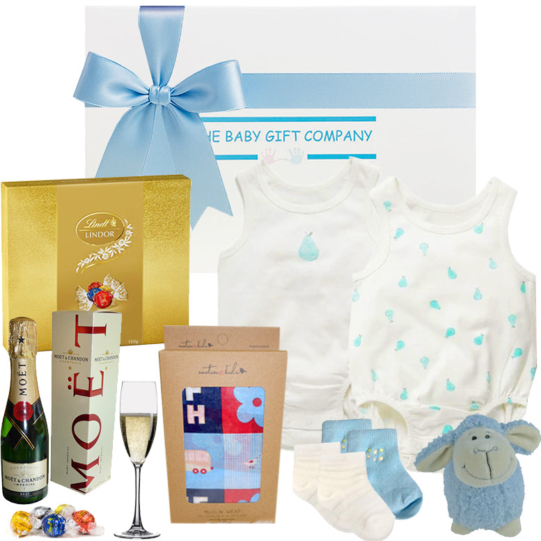 Collection of baby gift items including a moet bottle, lamb toy, and other products with a blue ribbon on a white background.