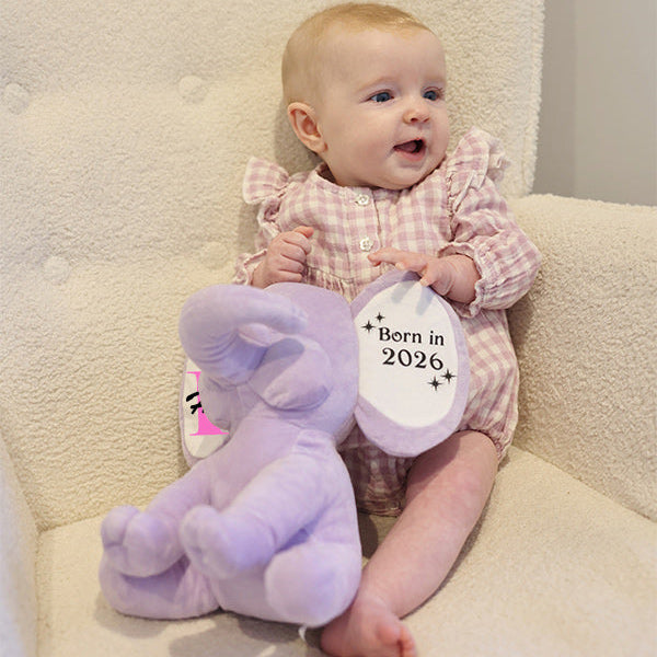 Baby sitting in chair with Purple Plush Elephant