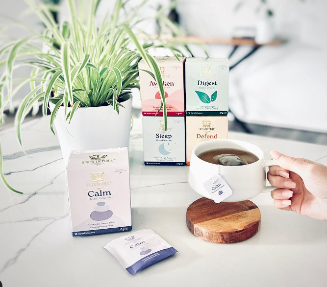 Tea packaging with a cup of tea on a marble surface, including 'Calm', 'Awaken', 'Sleep', 'Digest', and 'Defend' boxes.