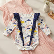 Rainbow print baby romper on pretty table 