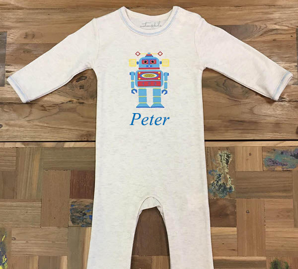 Baby onesie with robot design and 'Peter' text on a wooden surface