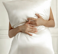Person holding a white pillow with a soft focus background