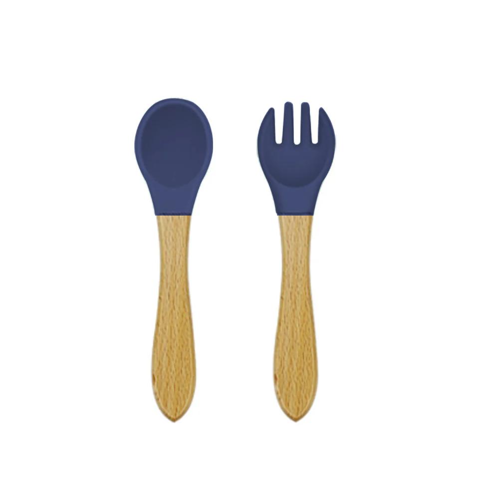 Navy blue spoon and fork with wooden handles on a white background