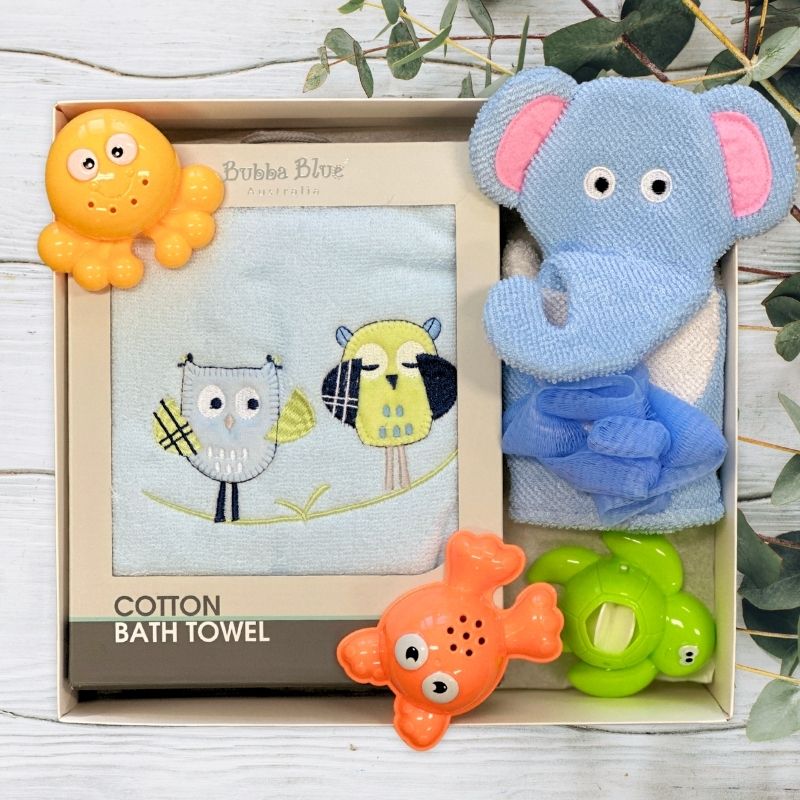 Baby bath towel set with toys in a decorative box on a light wooden background