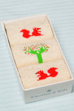 Set of three socks with red squirrels and green trees in a box labeled 'Emotion & Kids'.