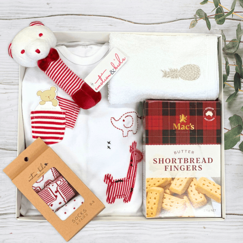 Baby gift set with toys, clothes, and a box of shortbread fingers from The Baby Gift Company