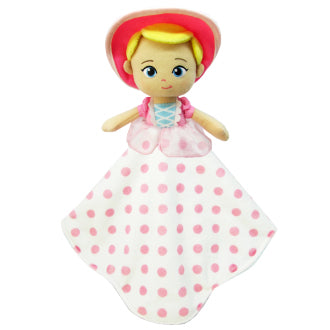 Toy doll with pink polka dot blanket on a white background