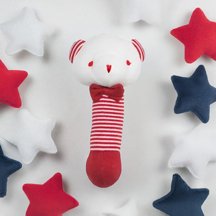 White bear-shaped rattle with red and white stripes surrounded by red, white, and blue stars on a light gray background