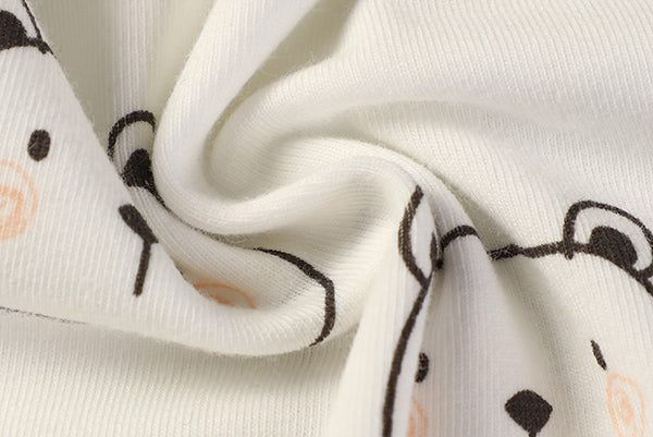 Close-up of white fabric with black and orange cat illustrations.