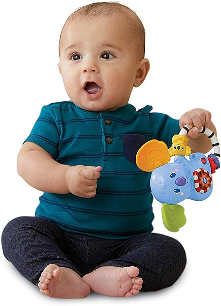 Baby holding a colorful toy with a white background