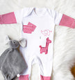 Baby onesie with red and white patterns on a fluffy white surface.
