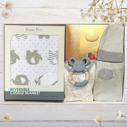 Baby gift set with items including a teether, box of Lindor chocolates, and baby bath products.