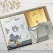 Baby gift set with clothing, toys, and blanket in a gift box from The Baby Gift Company.