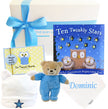 Baby gift set with teddy bear, book, and cards on a white background