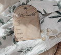 Hello World Wooden Birth Announcement Disc on a cotton floral background