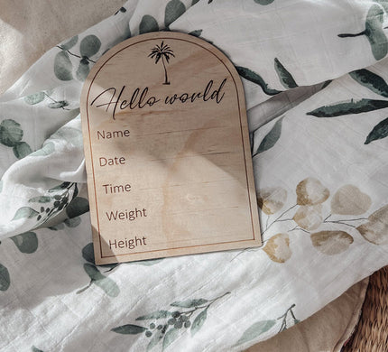 Hello World Wooden Birth Announcement Disc on a cotton floral background