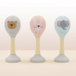 Three baby rattles with animal faces on table