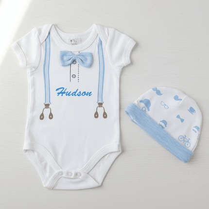 White baby onesie with blue bow tie and matching hat on a light gray background